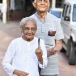 अमिट स्याही का निशान दिखाते दंपति