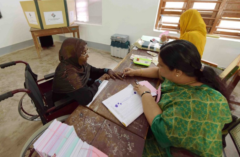 अमिट स्याही लगाते मतदान अधिकारी
