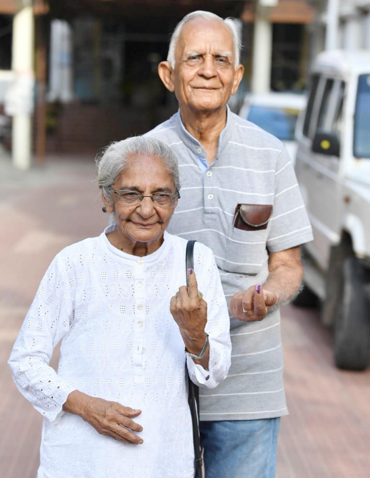 अमिट स्याही का निशान दिखाते दंपति